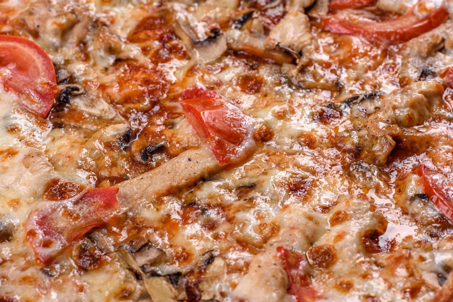 deliciosa pizza italiana fresca com cogumelos e tomates em um fundo escuro de concreto foto