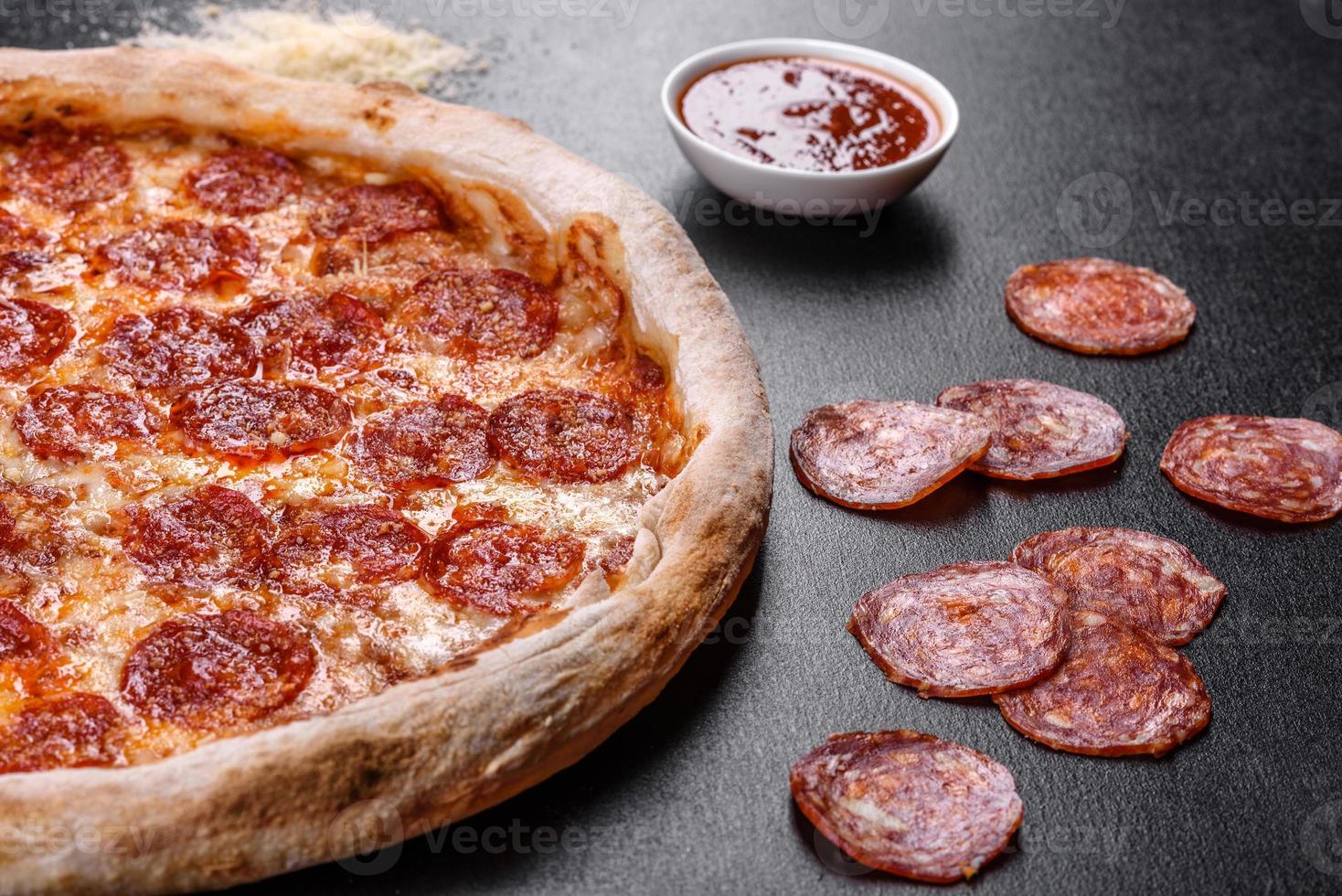 pizza de calabresa com molho de pizza, queijo mussarela e calabresa foto