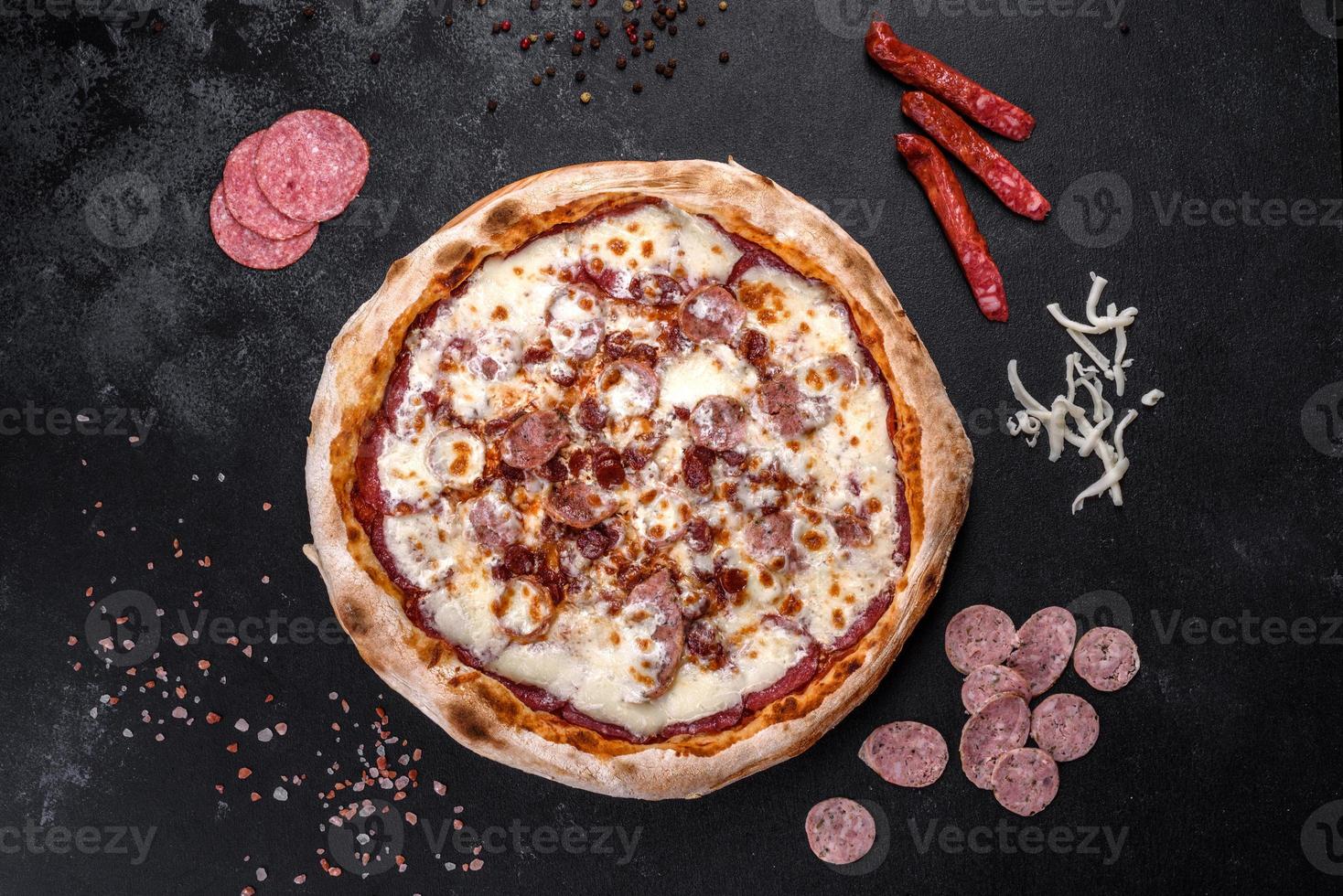 deliciosa pizza italiana fresca com quatro tipos de carne em um fundo escuro de concreto foto