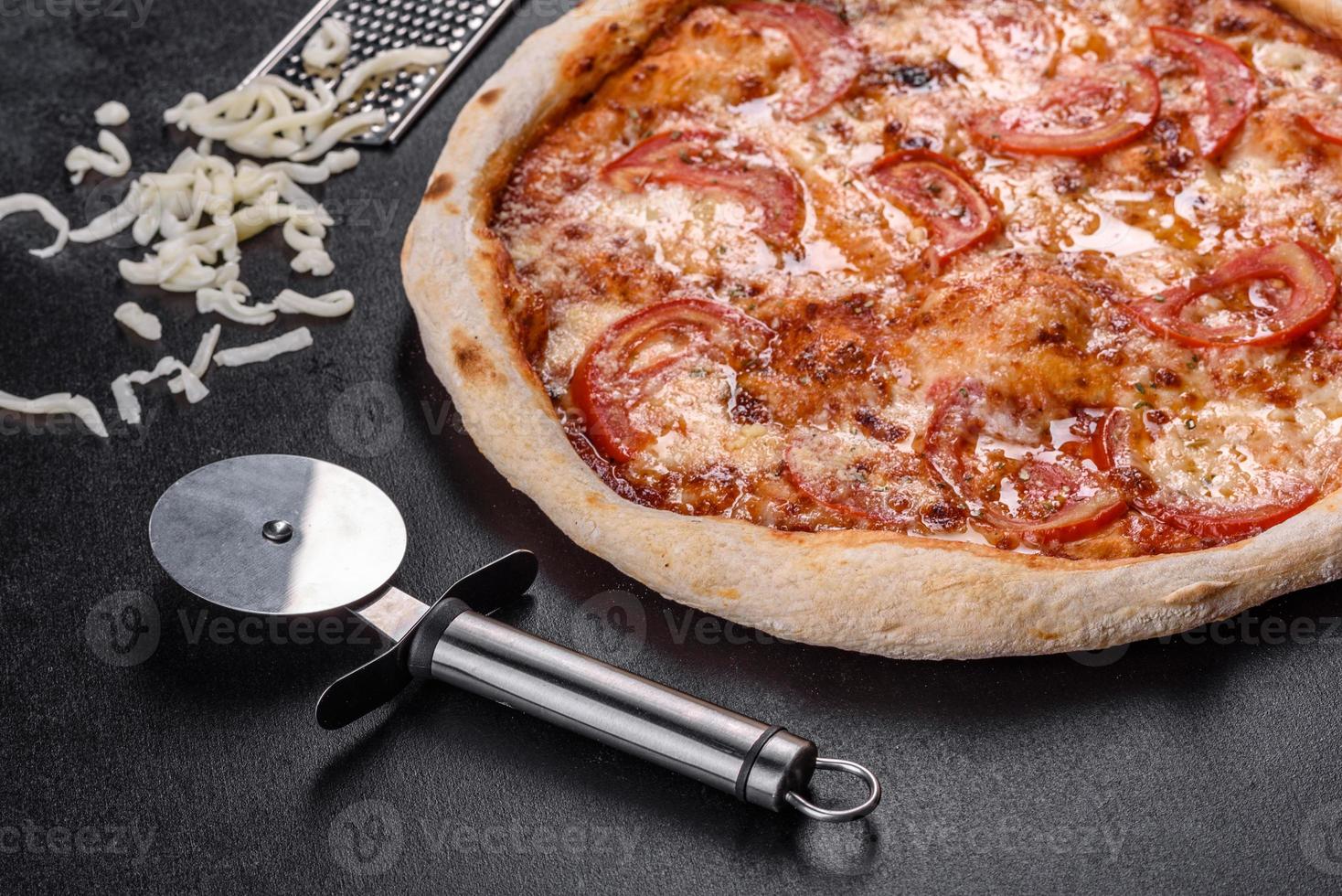 deliciosa pizza italiana fresca com cogumelos e tomates em um fundo escuro de concreto foto