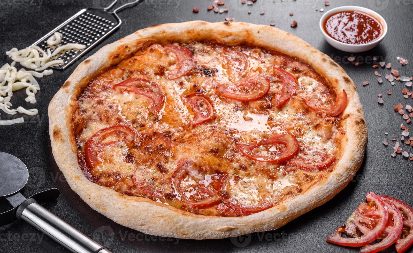 deliciosa pizza italiana fresca com cogumelos e tomates em um fundo escuro de concreto foto