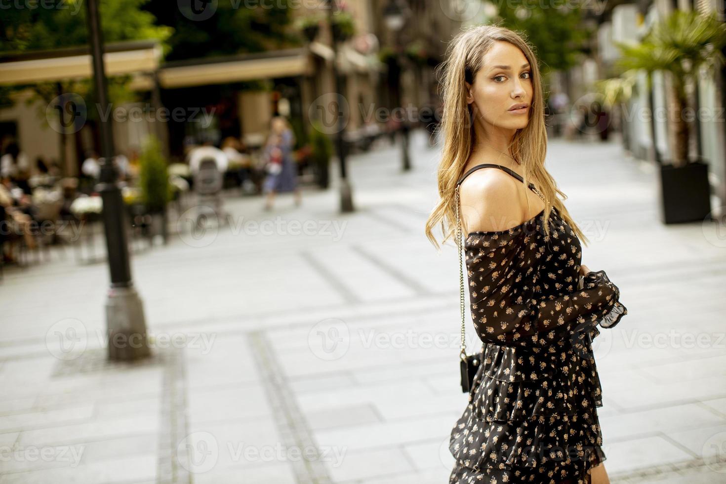 jovem morena de cabelos longos caminhando na rua foto