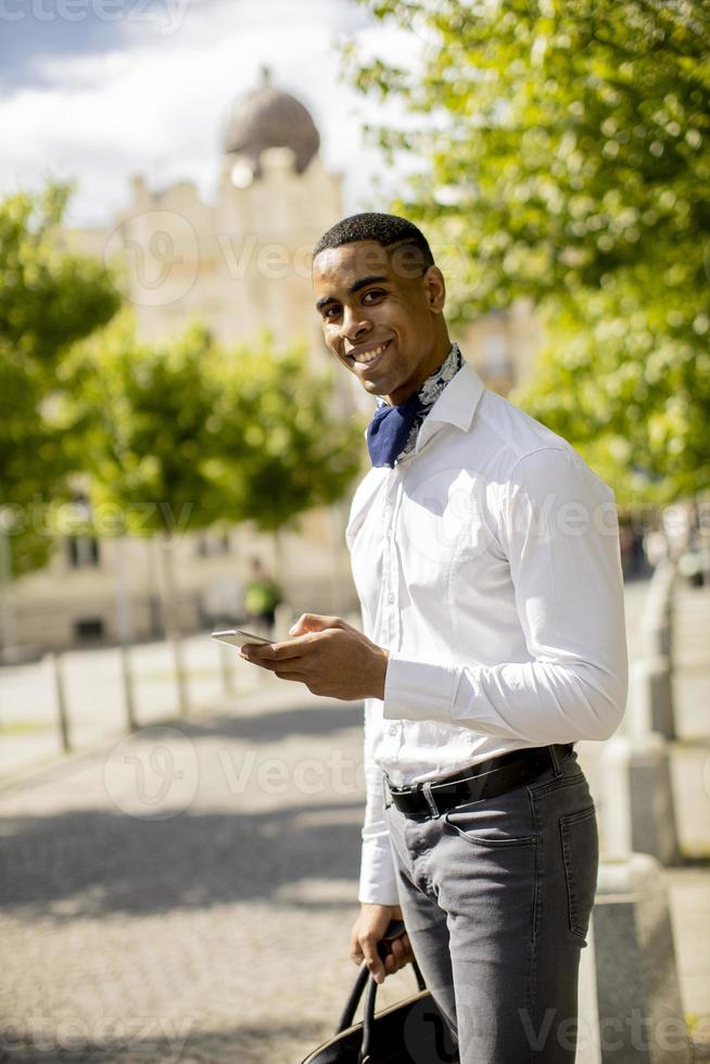 jovem empresário afro-americano usando um telefone celular foto