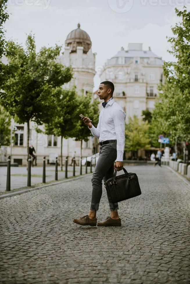 jovem empresário afro-americano usando um telefone celular foto