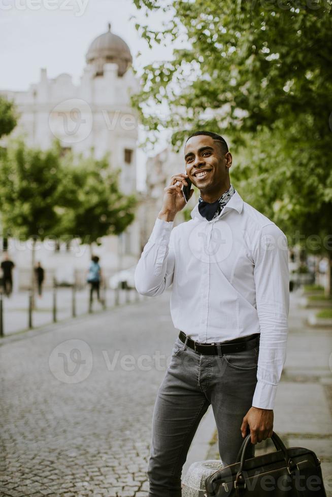 jovem empresário afro-americano usando um telefone celular foto