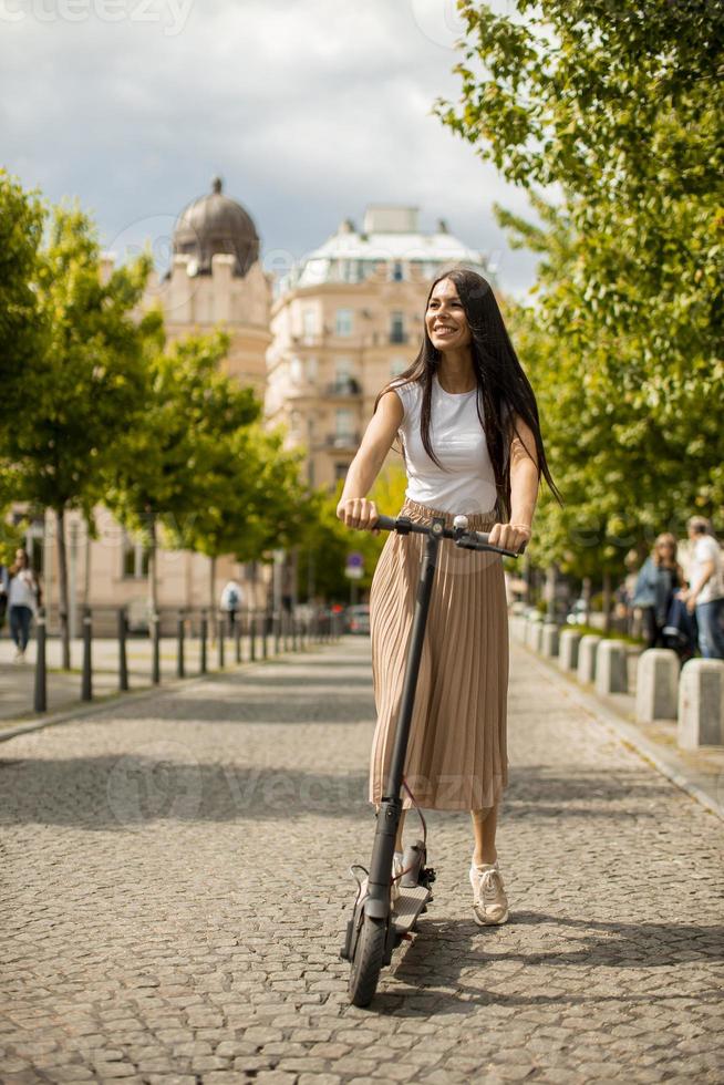 jovem andando de scooter elétrica em uma rua foto