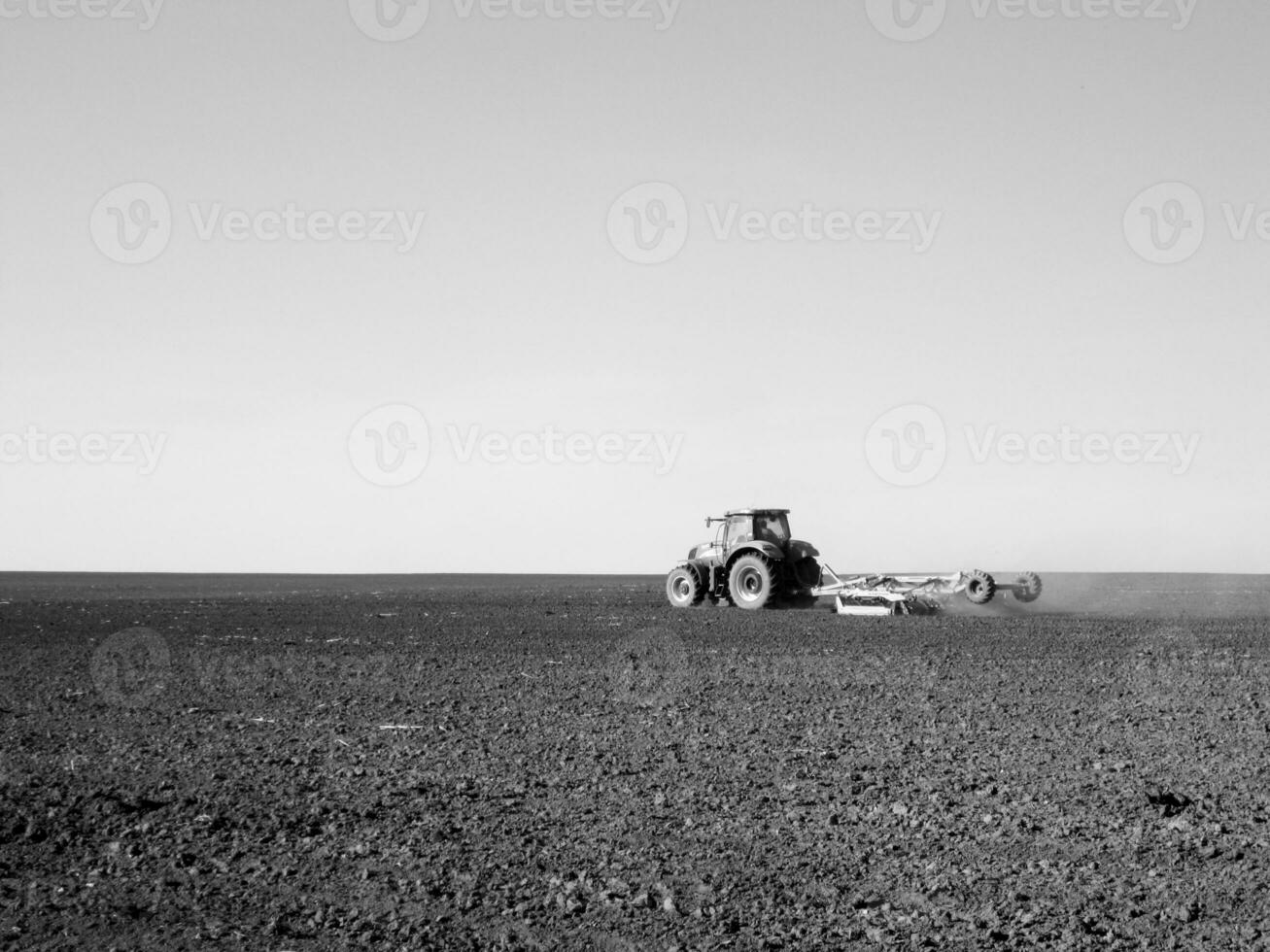 arado campo de trator dentro Preto solo em aberto campo natureza foto