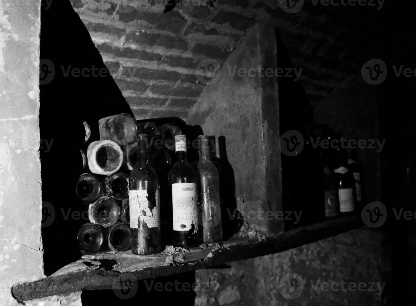 garrafas de vinho muito antigas estão na adega escura retrô foto