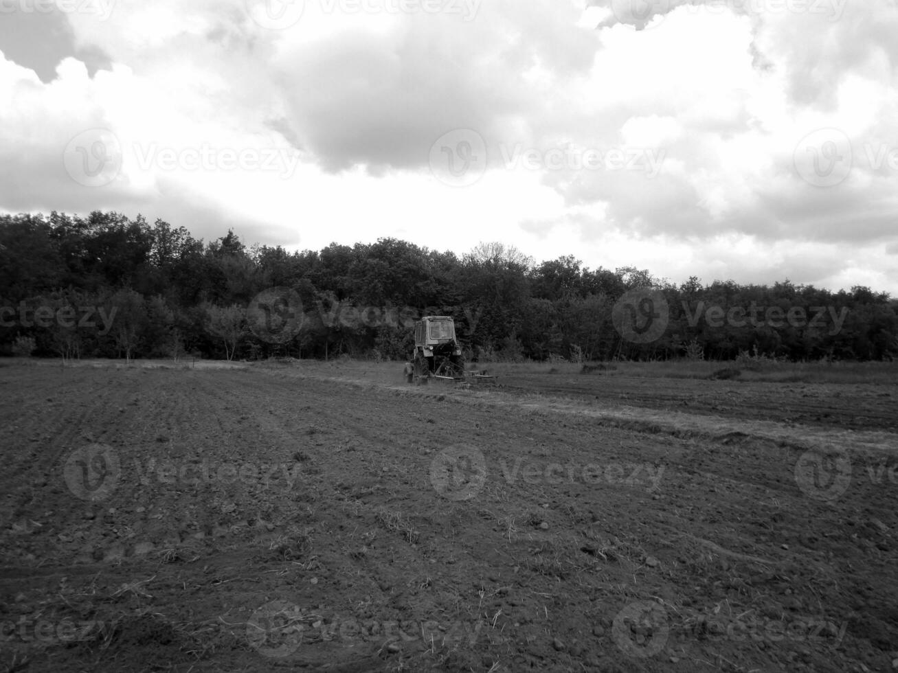 arado campo de trator dentro Preto solo em aberto campo natureza foto