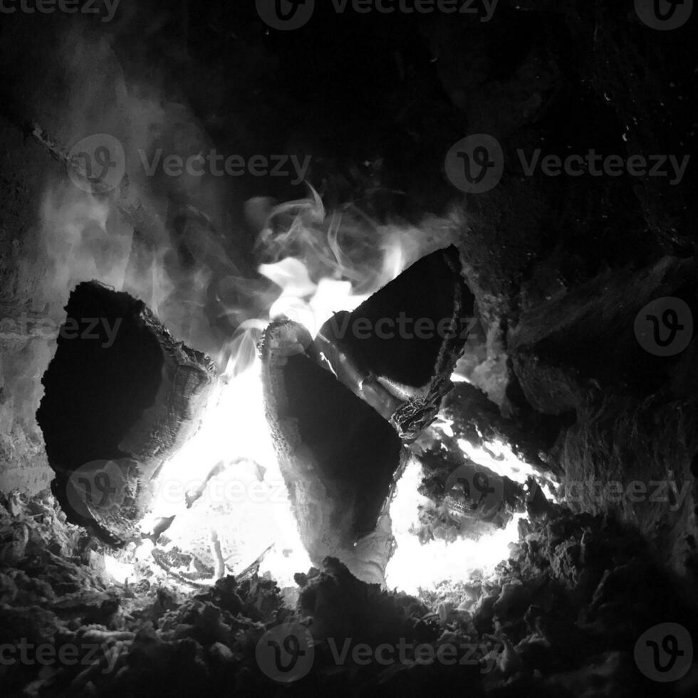 bela chama de madeira marrom escuro carvão em fogo amarelo brilhante dentro do braseiro de metal foto
