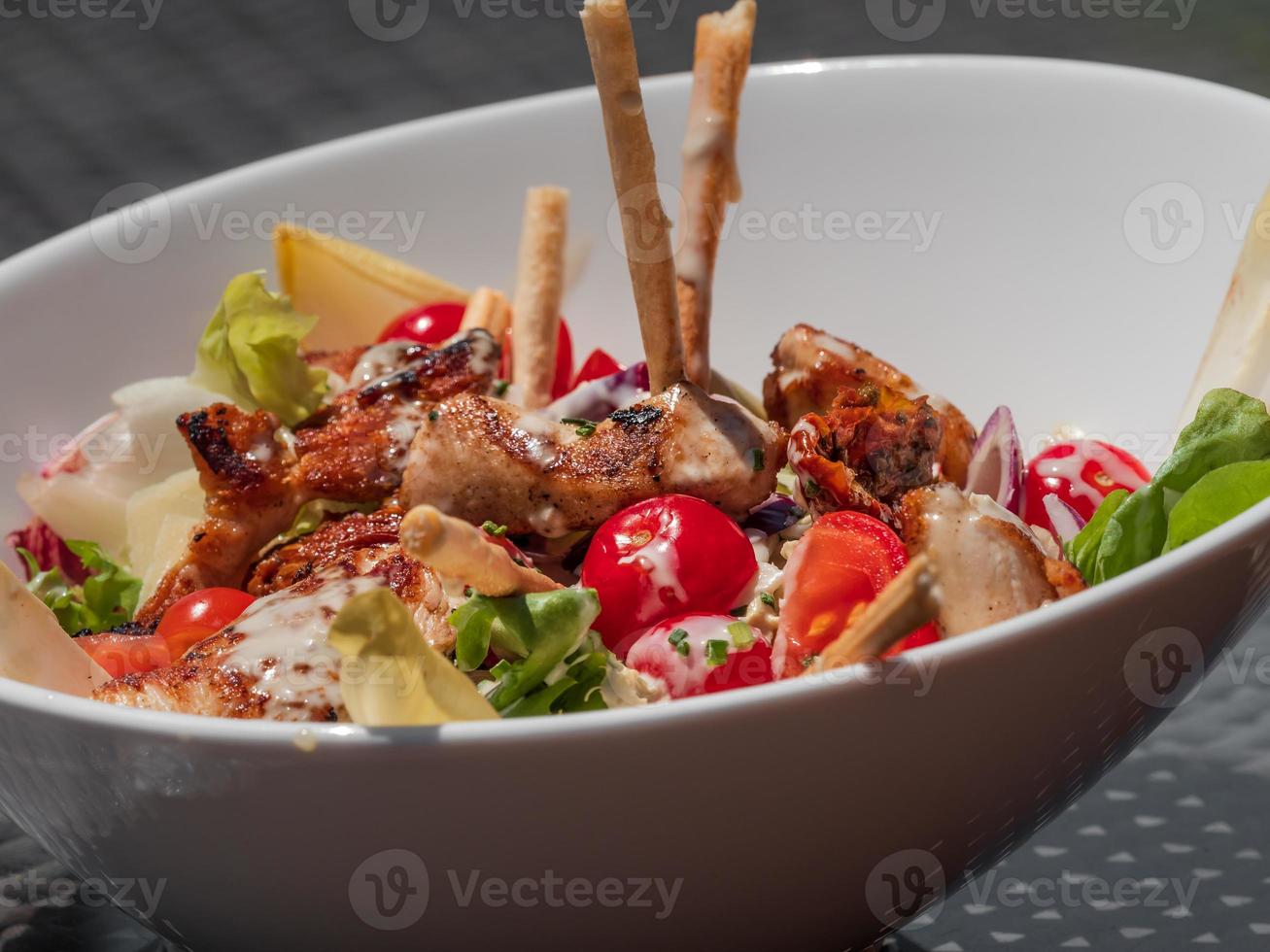 Salada deliciosa e lindamente preparada com frango e legumes. foto