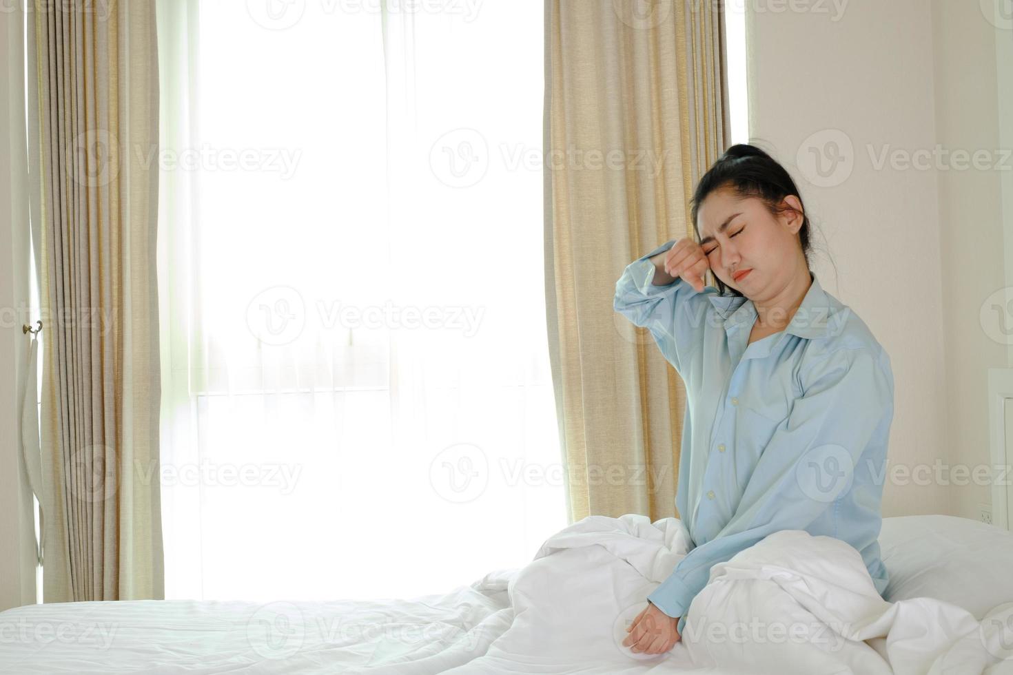 mulheres asiáticas acordam em uma cama no quarto foto
