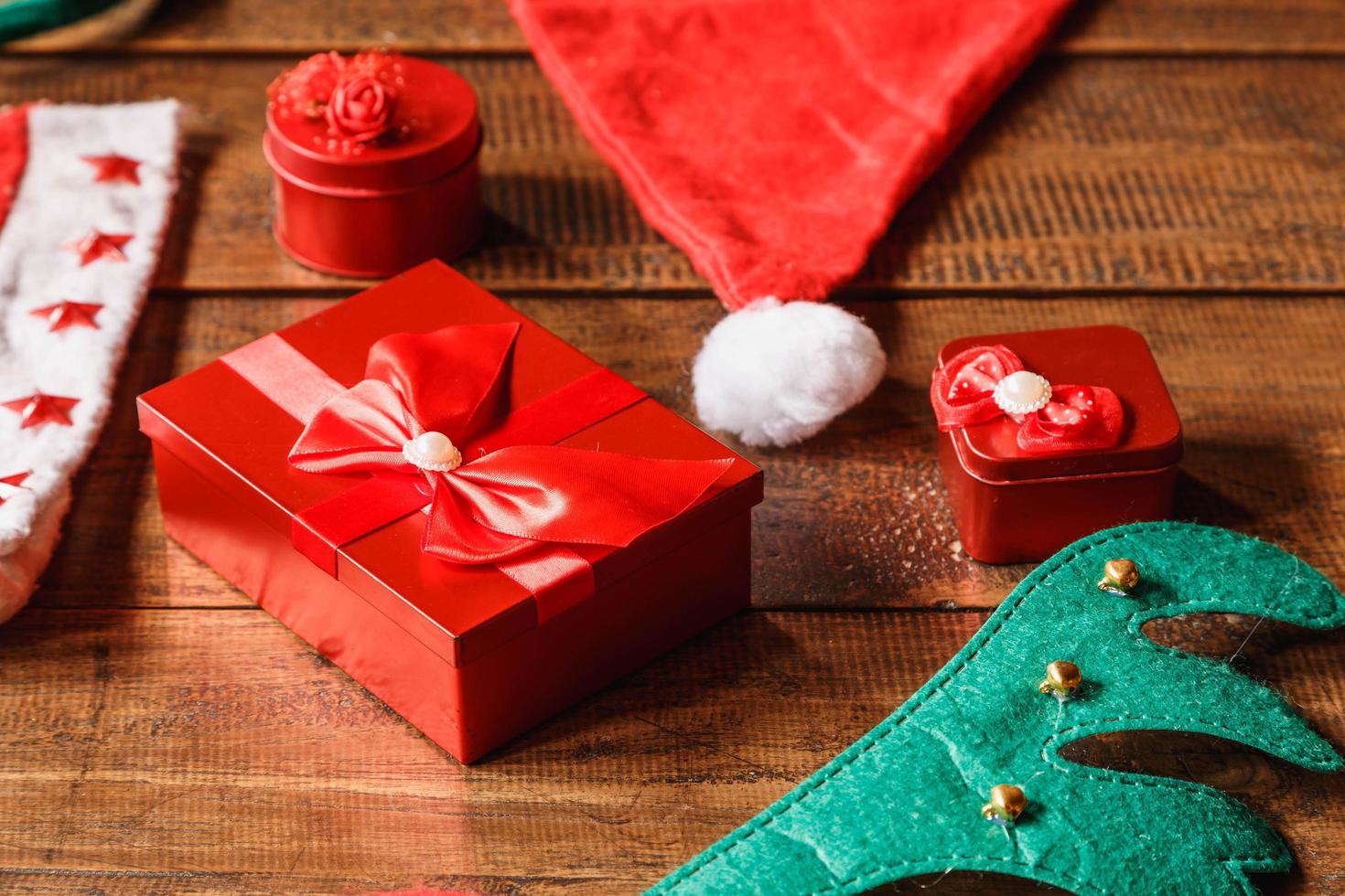 caixa de presente vermelha e chapéu de Papai Noel em fundo de madeira foto