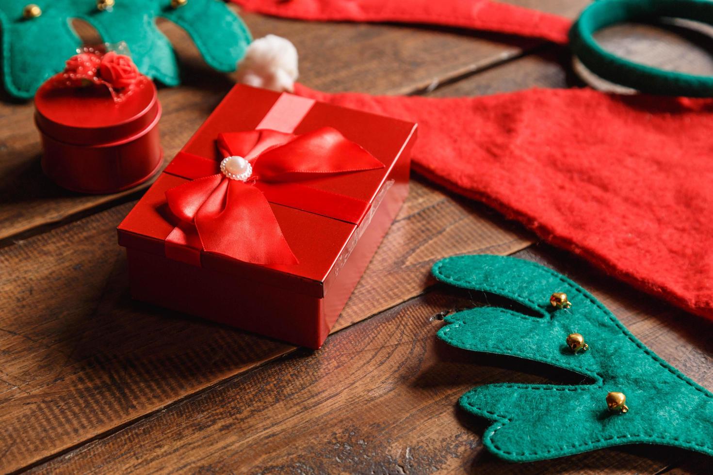 caixa de presente vermelha e chapéu de Papai Noel em fundo de madeira foto
