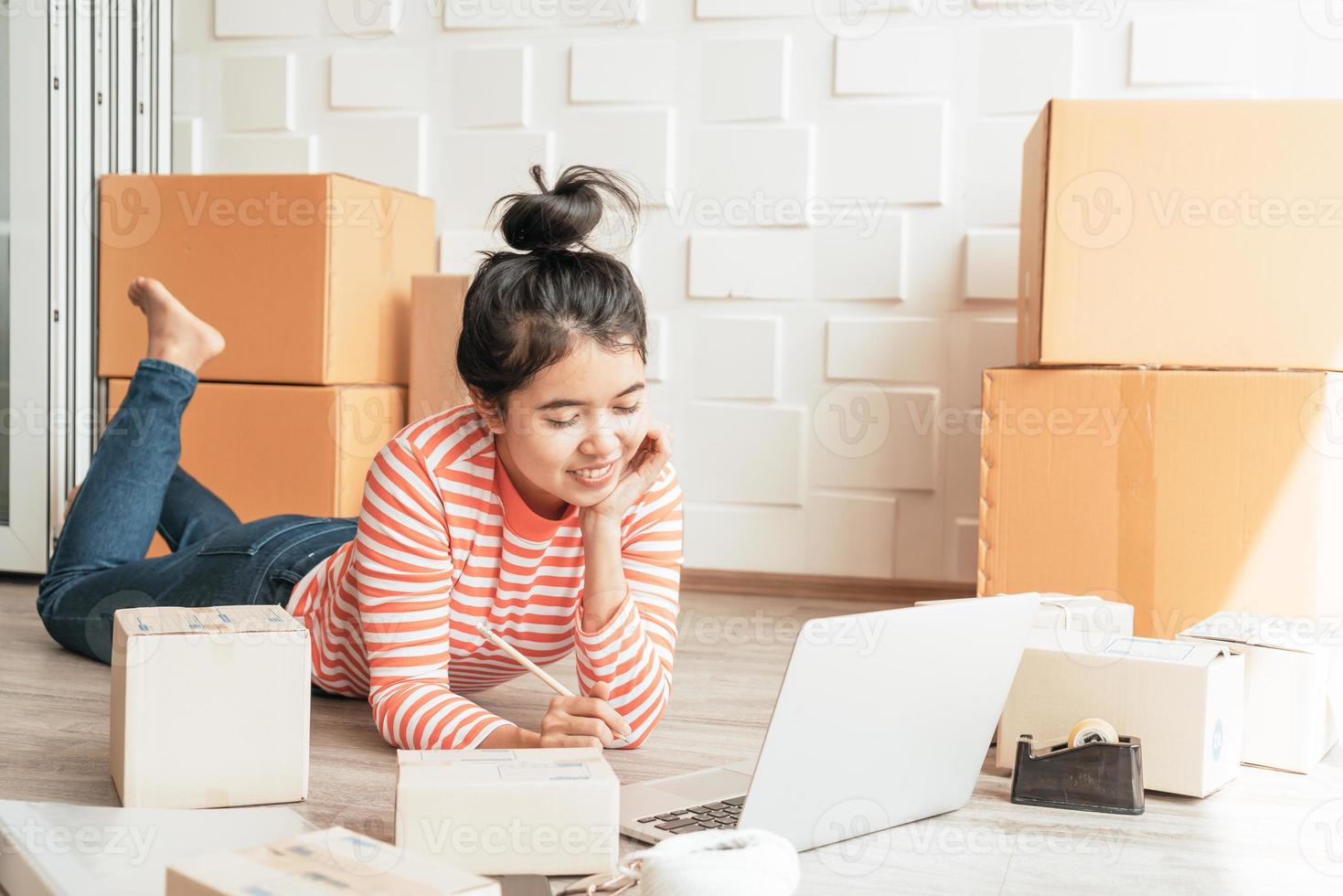 Proprietário de empresa mulher asiática trabalhando em casa com caixa de embalagem no local de trabalho - empreendedor de compras online de pmes ou conceito de trabalho freelance foto