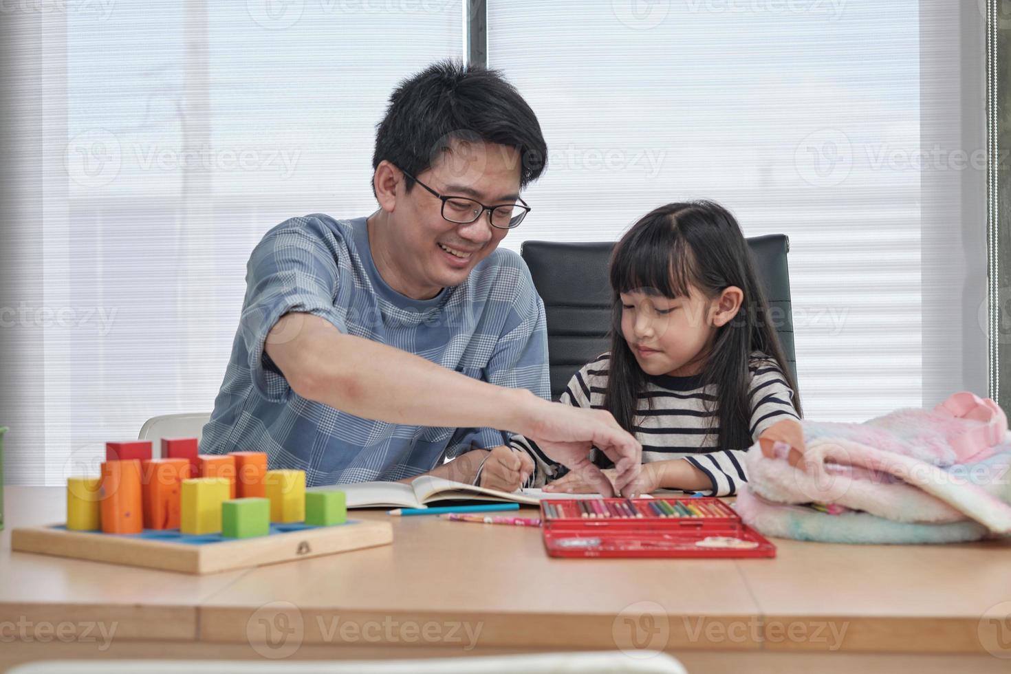 pai asiático está ensinando arte para sua filha. foto