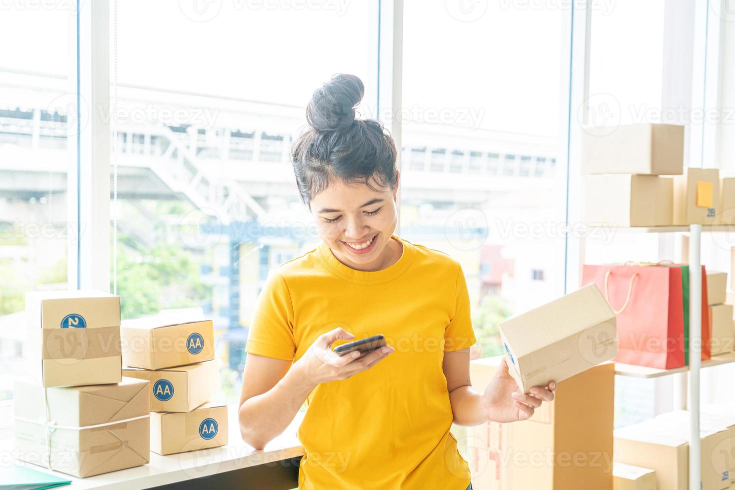 Proprietário de empresa mulher asiática trabalhando em casa com caixa de embalagem no local de trabalho - empreendedor de compras online de pmes ou conceito de trabalho freelance foto