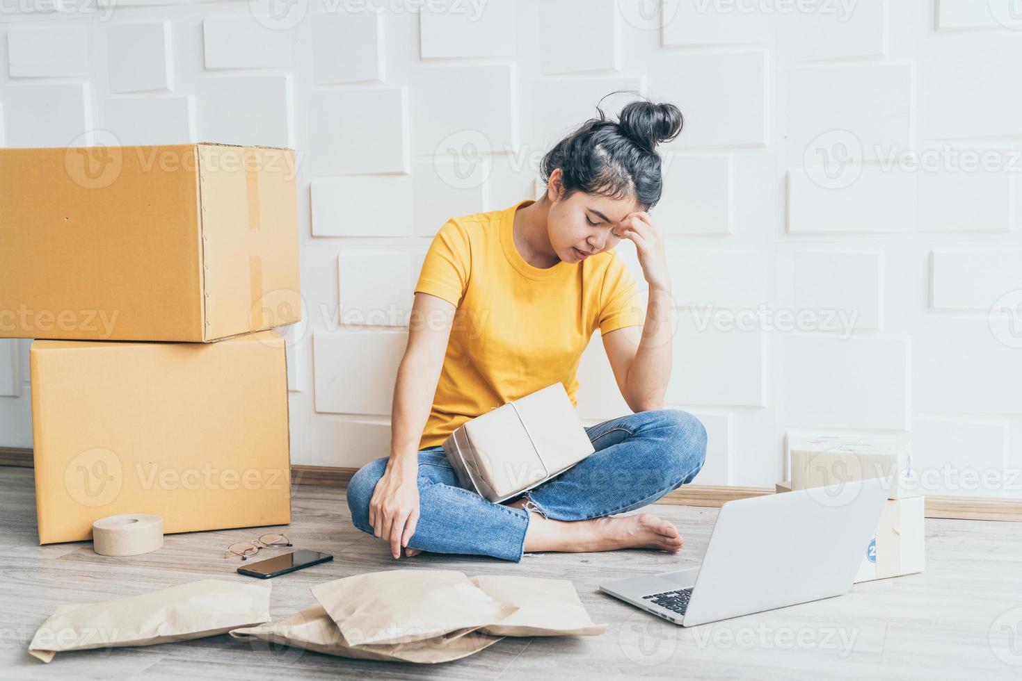 jovem mulher asiática se sentindo estressada ou deprimida na frente de seu laptop - conceito de venda online foto