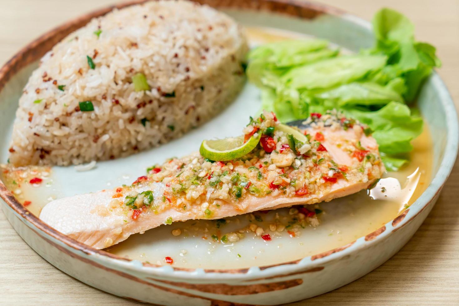 Quinoa arroz frito com salmão cozido no vapor com molho de pimenta e limão - estilo de comida saudável foto