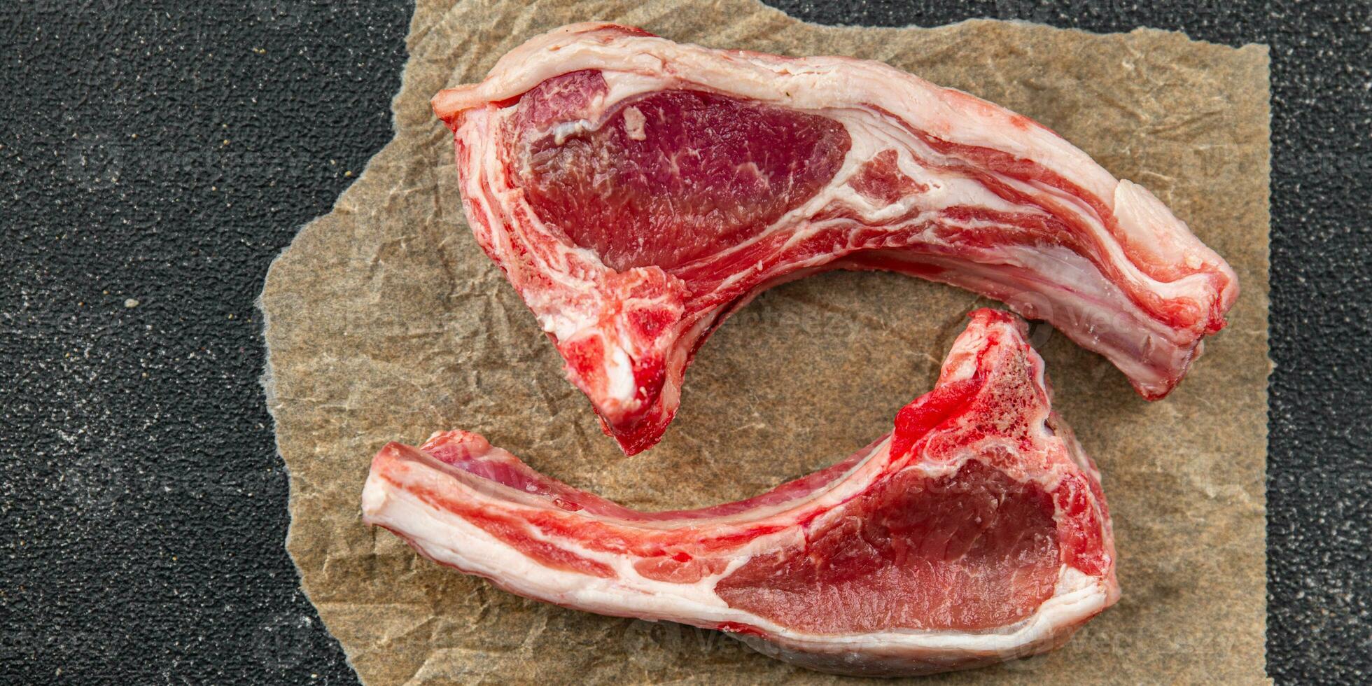 costeleta Cordeiro carne cru em a osso fatia refeição Comida lanche em a mesa cópia de espaço Comida fundo rústico topo Visão foto