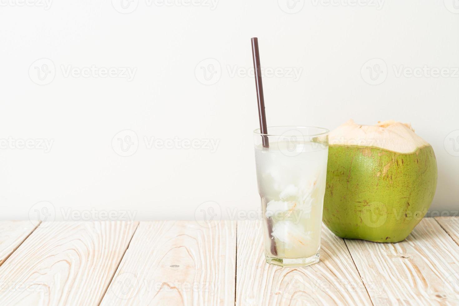 água de coco ou suco de coco em copo com cubos de gelo foto