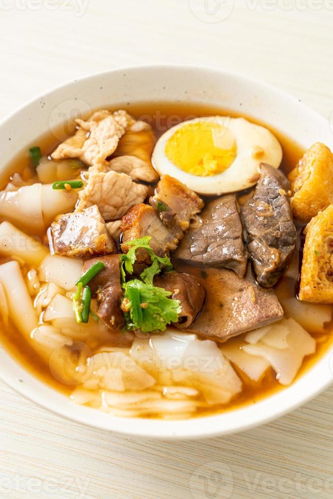 pasta de farinha de arroz ou quadrado de macarrão chinês cozido com carne de porco na sopa marrom - estilo de comida asiática foto