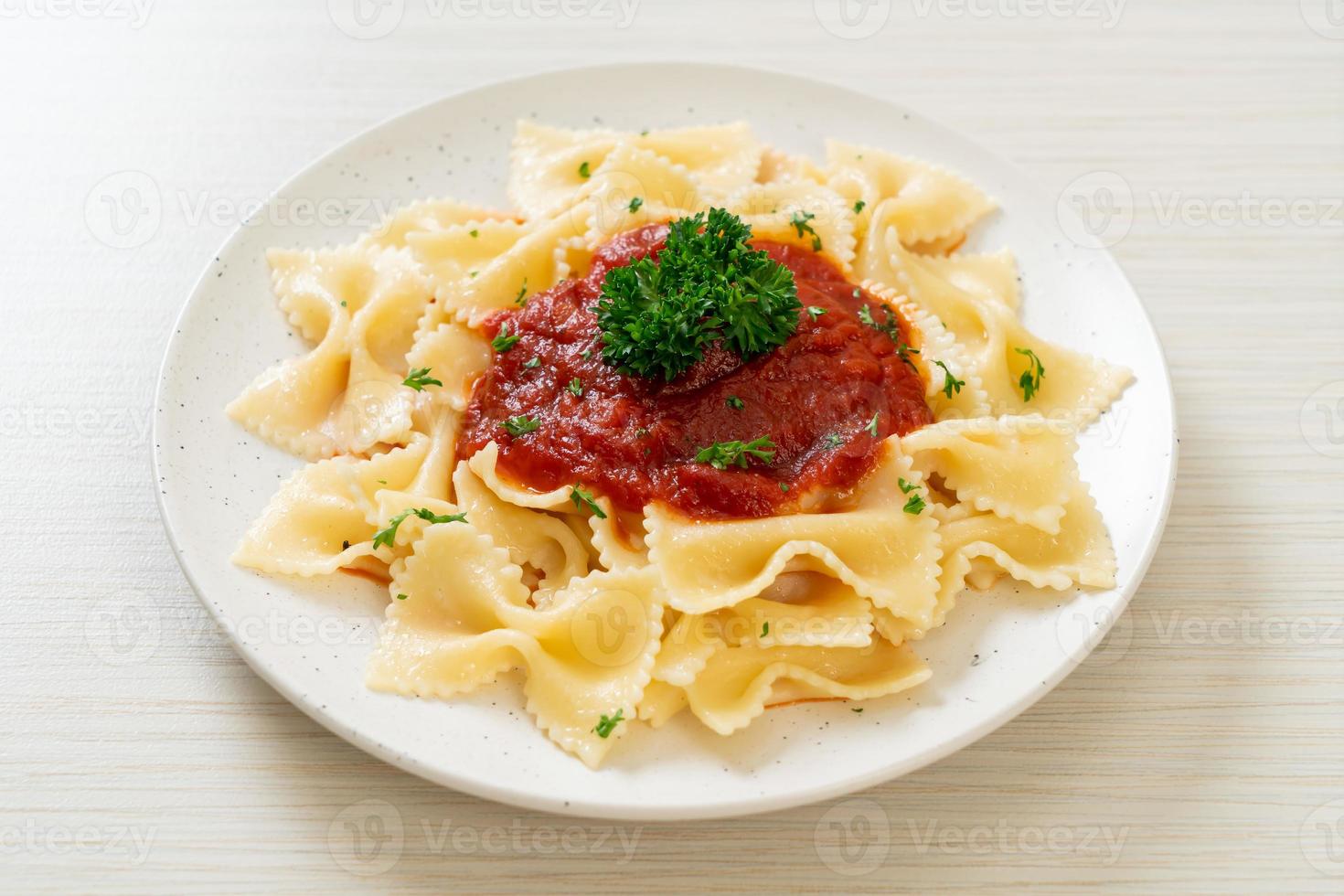 macarrão farfalle em molho de tomate com salsa - comida italiana foto