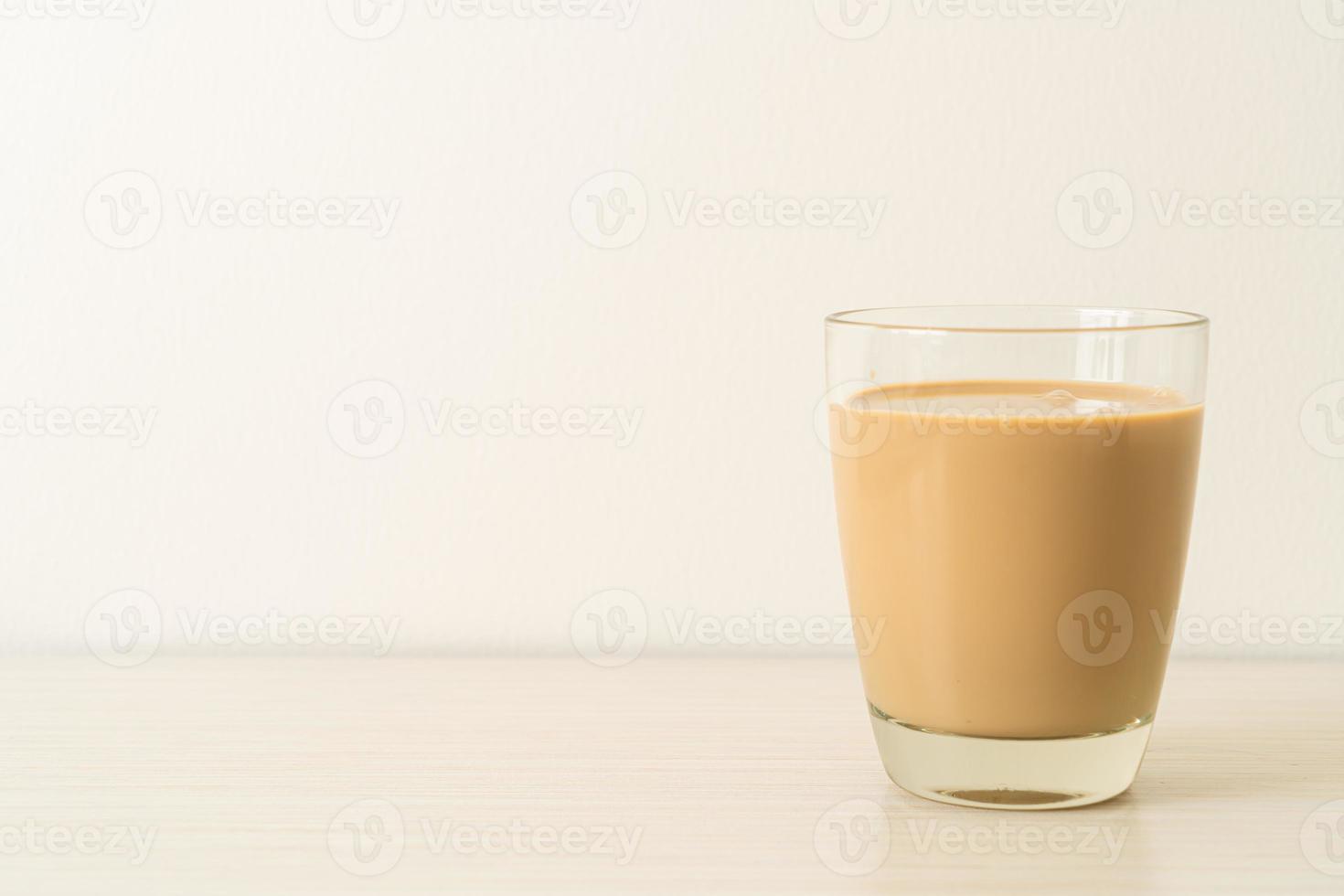 copo de café com leite com garrafas de café prontas para beber na mesa foto