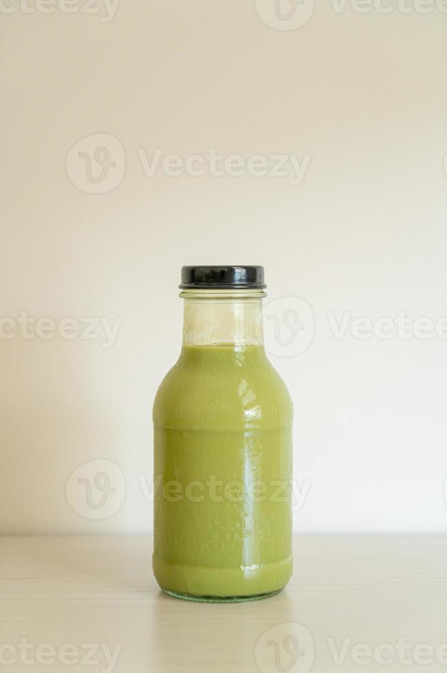 matcha chá verde com leite em garrafa de vidro na mesa foto