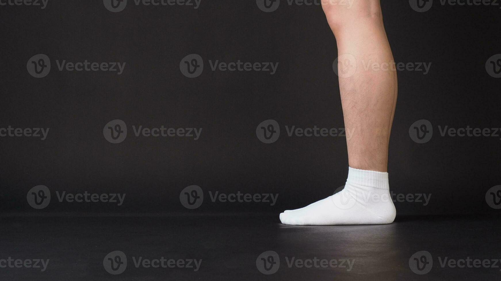 ásia masculino pernas vestem branco meia é isolado em Preto fundo foto
