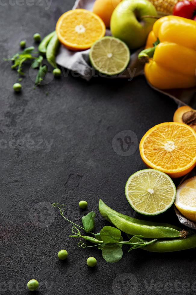 comida saudável. vegetais e frutas em um fundo preto de concreto. foto