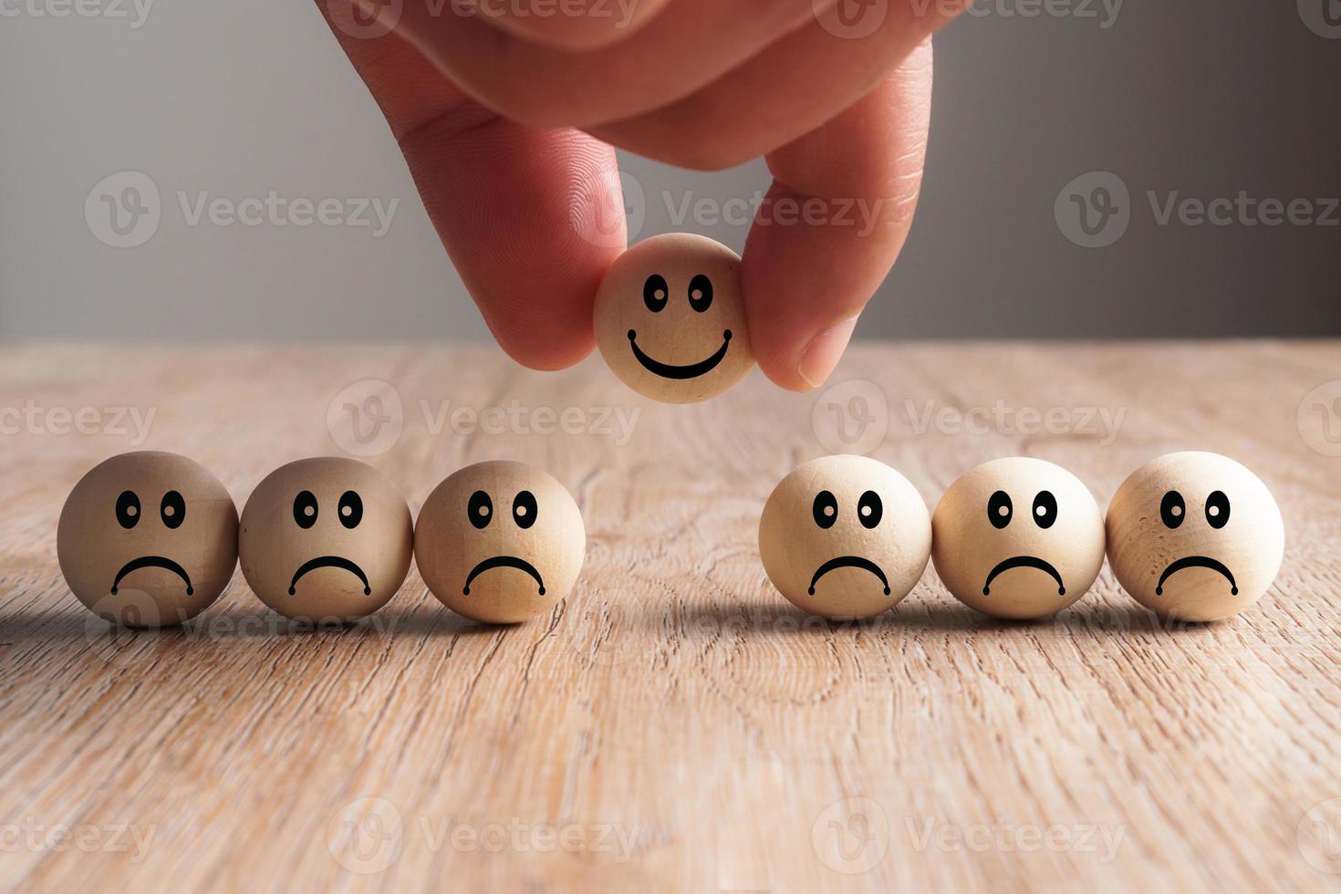 mão colocando uma bola de madeira sorridente, conceito de recrutamento foto