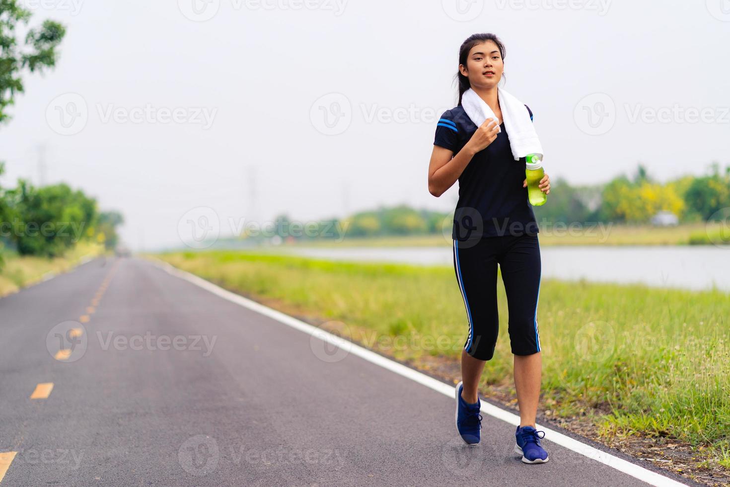 garota de esportes, mulher correndo na estrada, treinamento de mulher saudável foto