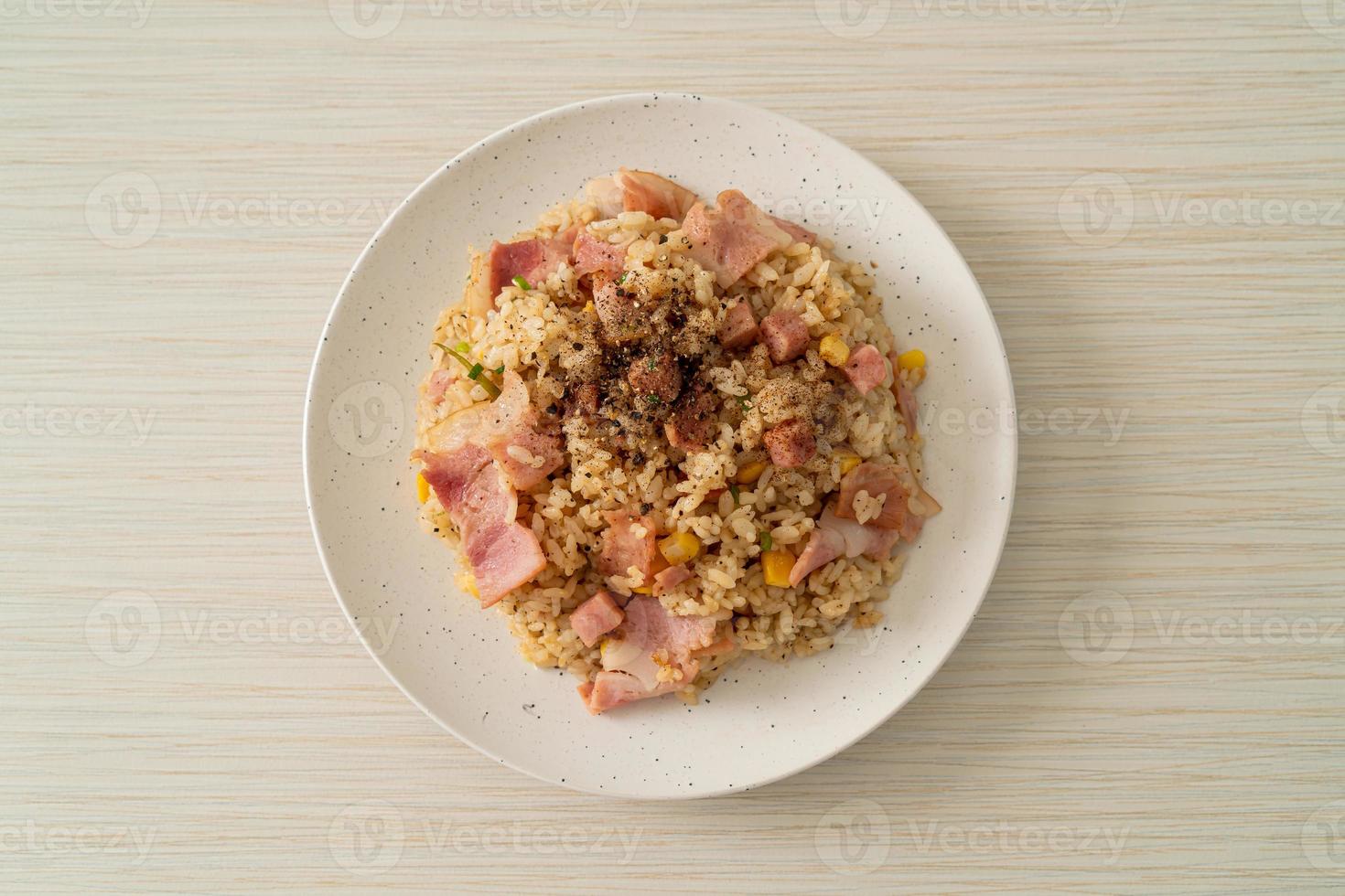 arroz frito com bacon, presunto e pimentão preto em prato branco foto