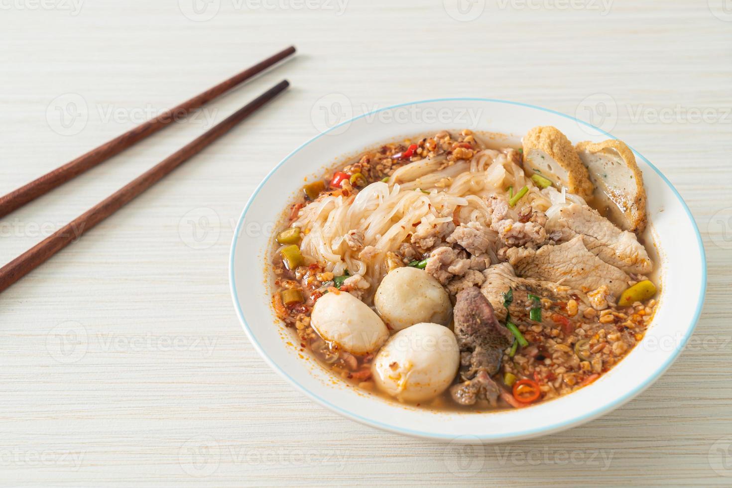 macarrão com carne de porco e almôndegas em sopa apimentada ou macarrão tom yum em estilo asiático foto