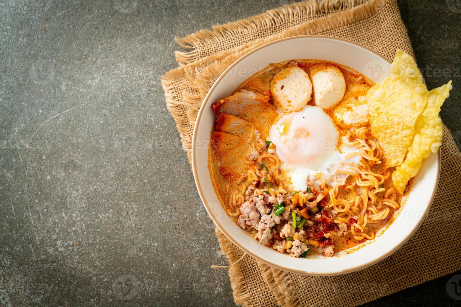 macarrão instantâneo com carne de porco e almôndegas em sopa picante ou macarrão tom yum em estilo asiático foto