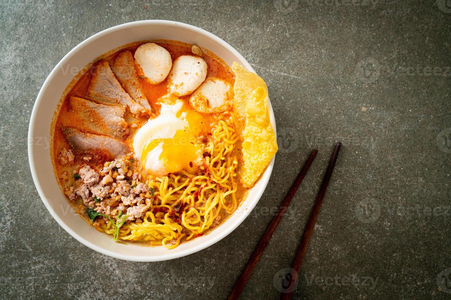 macarrão de ovo com carne de porco e almôndega em sopa picante ou macarrão tom yum em estilo asiático foto