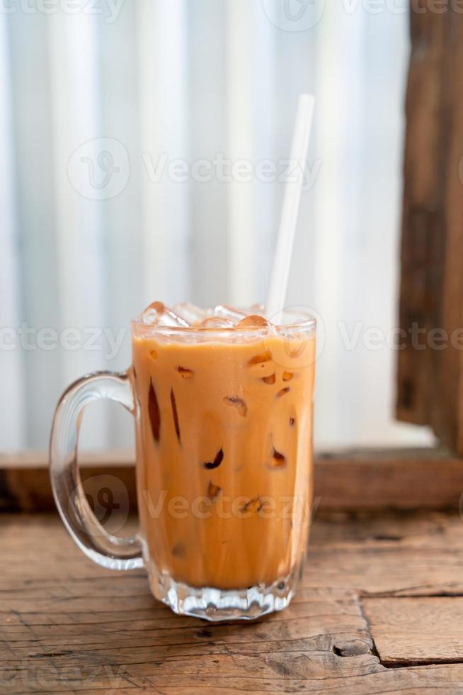 Copo de chá com leite tailandês gelado em café restaurante foto