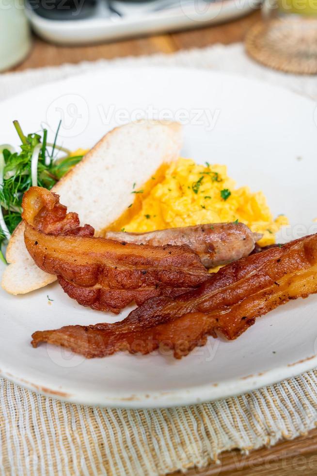 mexidos egga com bacon e salsicha no prato para o café da manhã foto