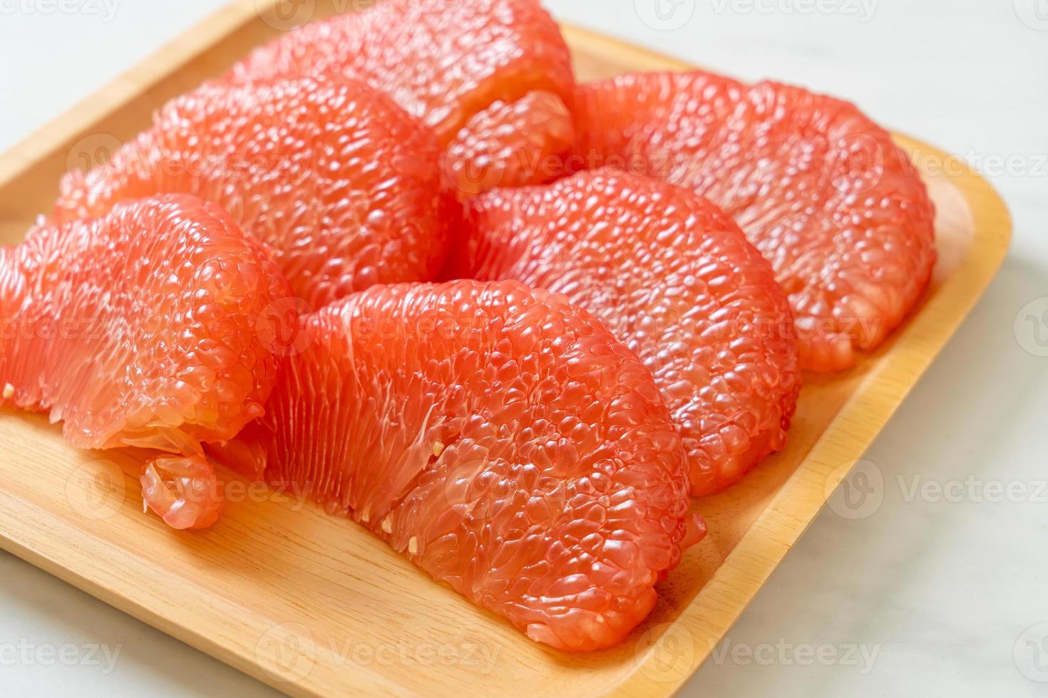 pomelo vermelho fresco ou toranja no prato foto