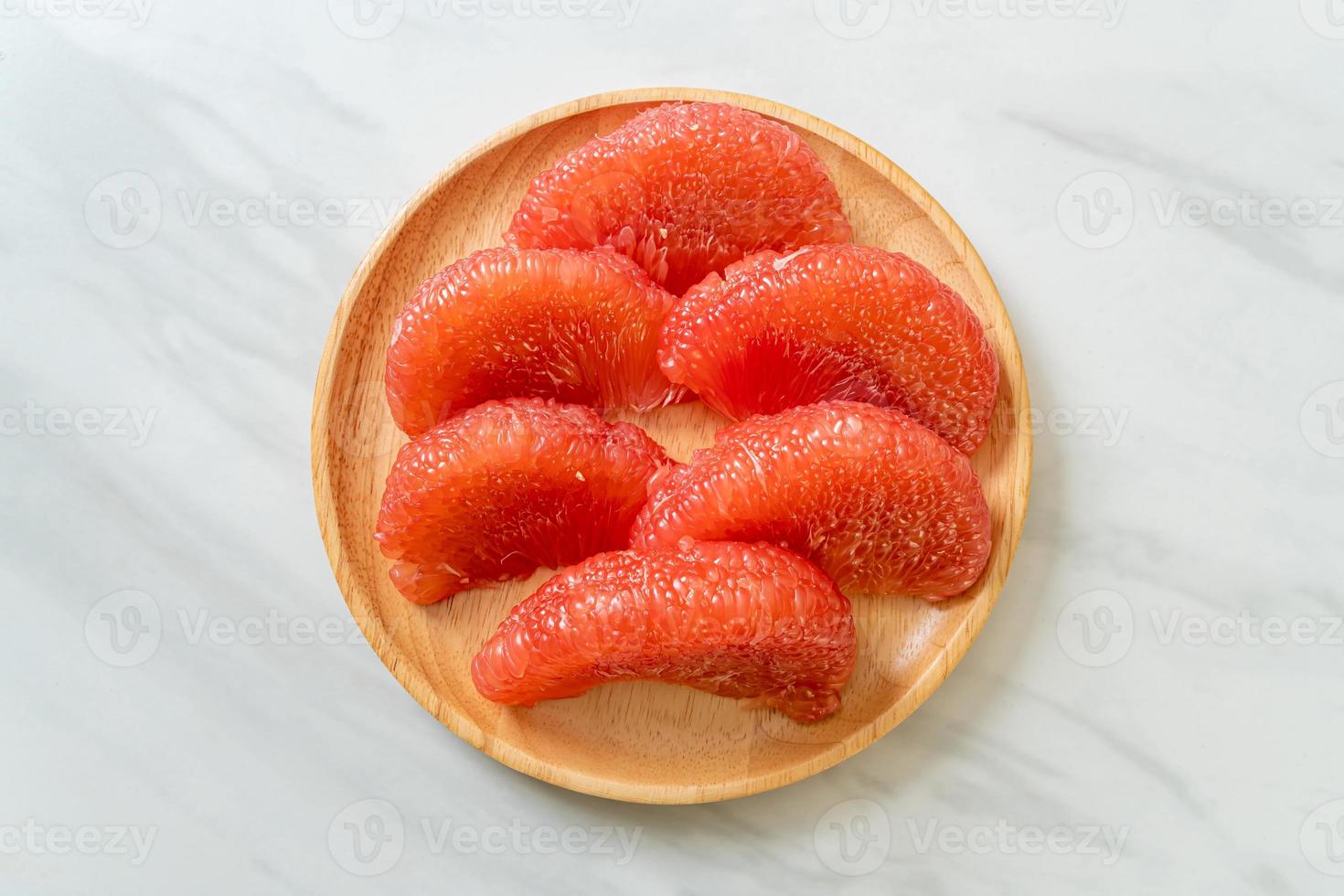 pomelo vermelho fresco ou toranja no prato foto