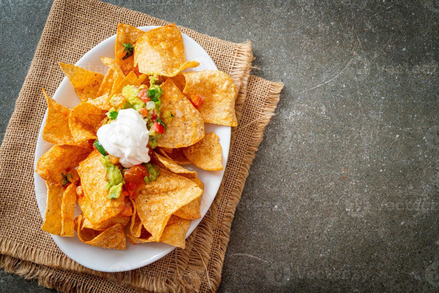 chips de tortilla de nachos mexicanos com jalapeño, guacamole, molho de tomate e molho foto