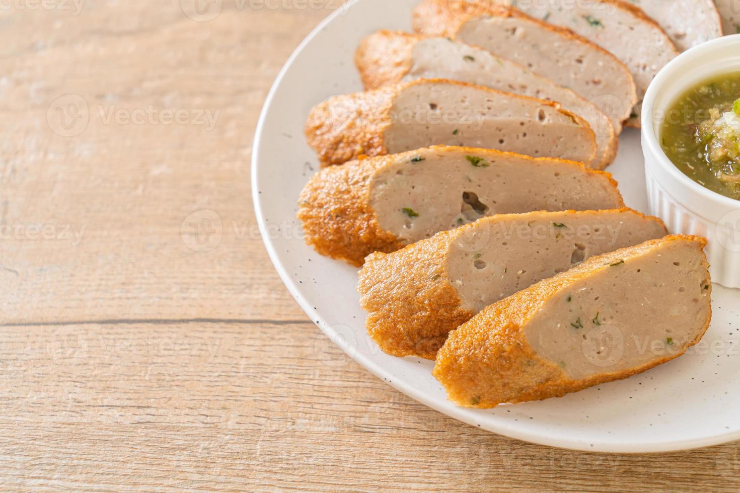 Bolo de peixe chinês frito ou linha de bolinho de peixe fatiado com molho picante de frutos do mar foto