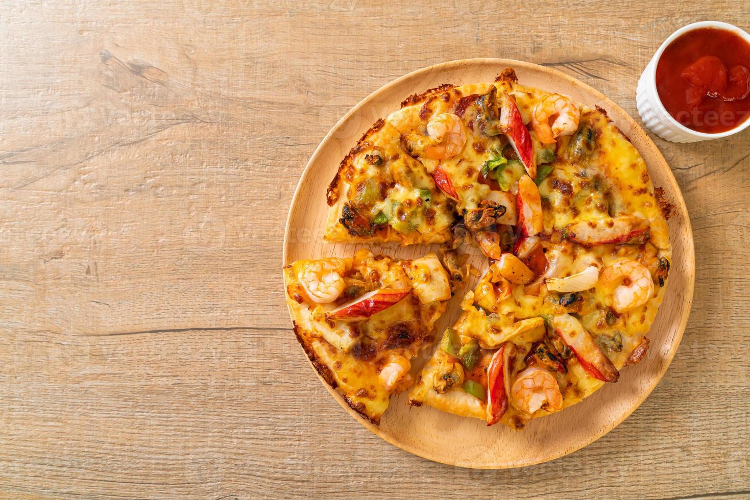 frutos do mar de camarão, polvo, mexilhão e pizza de caranguejo em bandeja de madeira foto