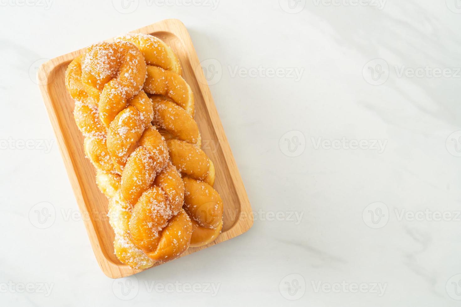 donut de açúcar em forma de espiral em placa de madeira foto