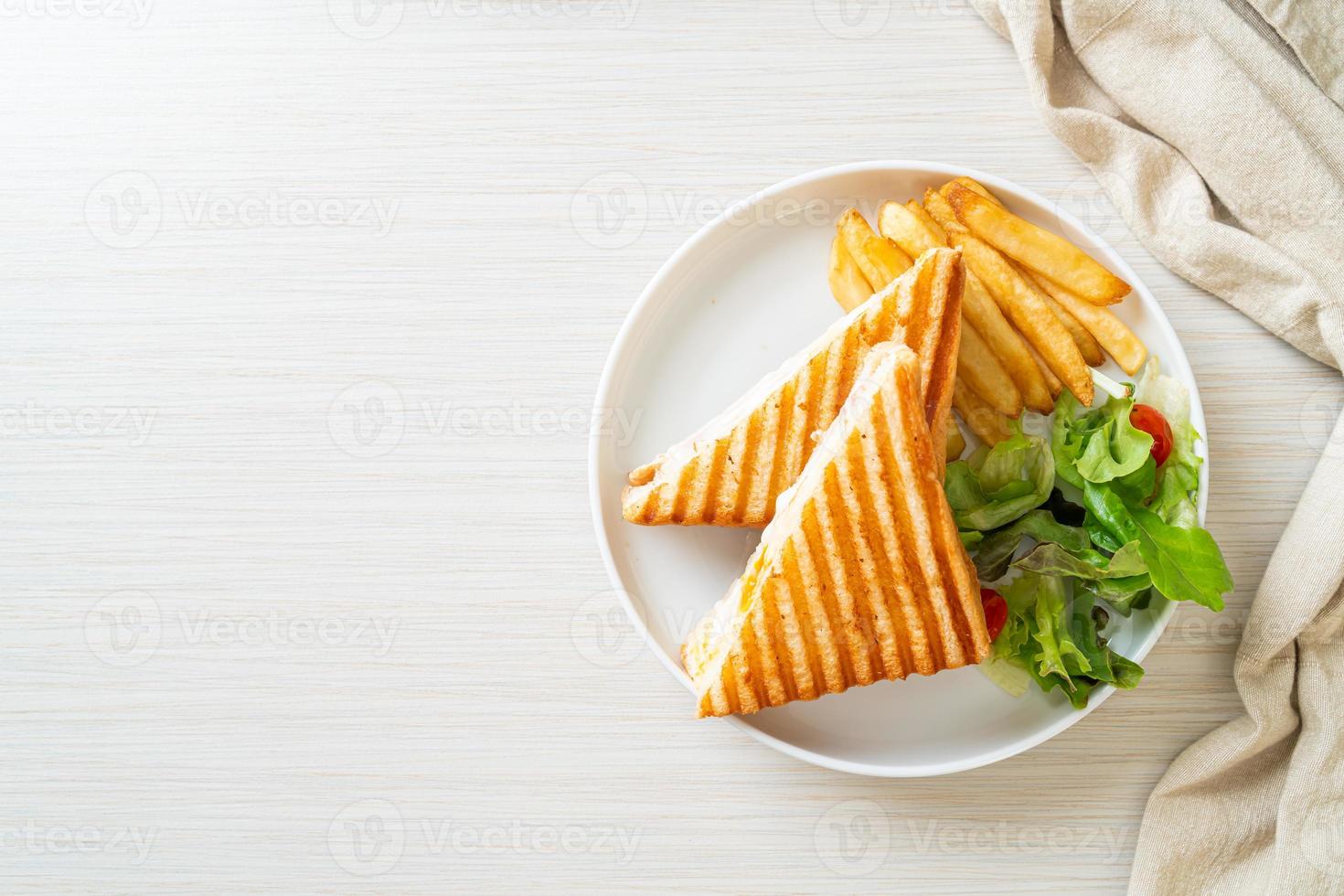 sanduíche de presunto e queijo com ovo e batata frita foto