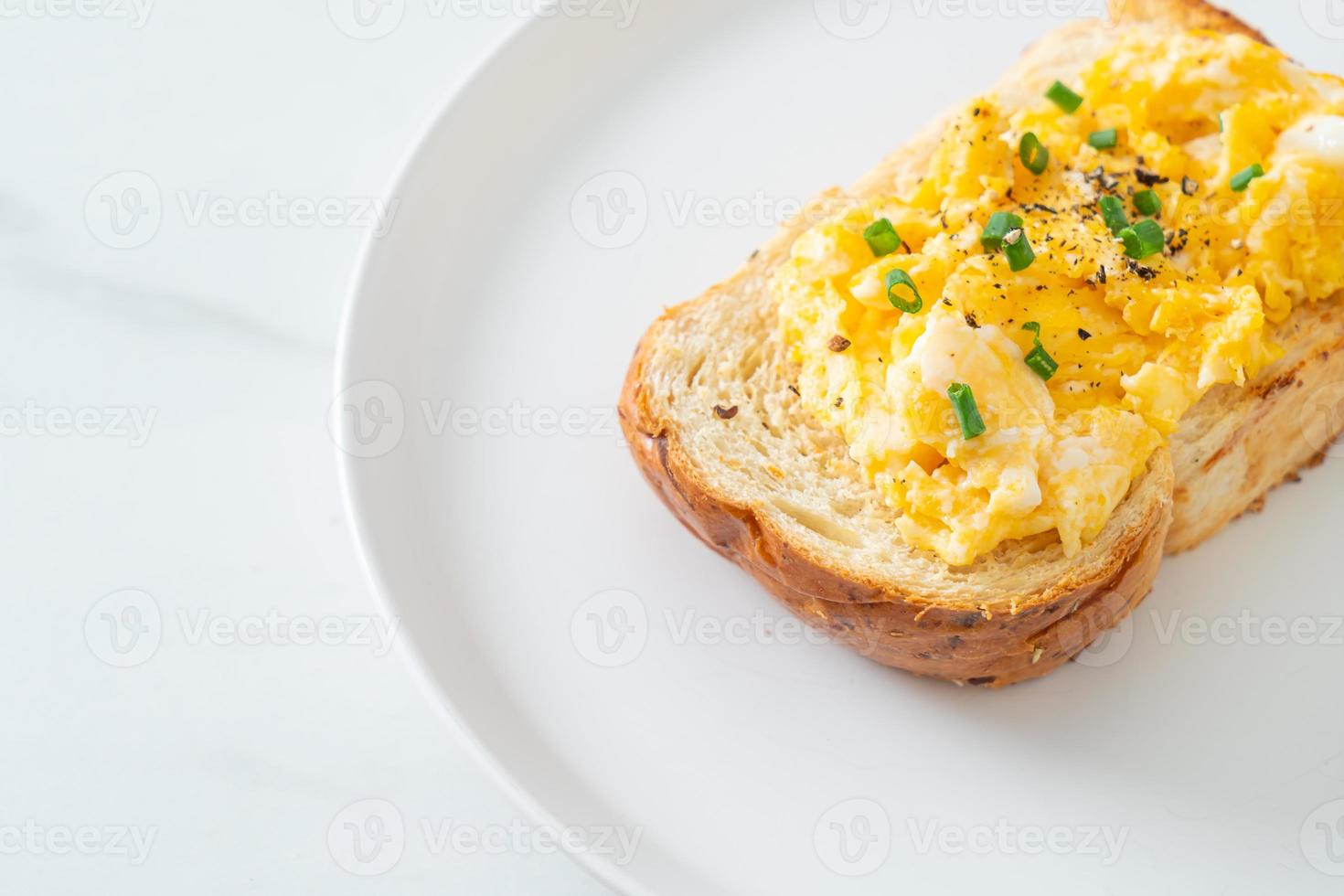 torrada de pão com ovo mexido no prato branco foto