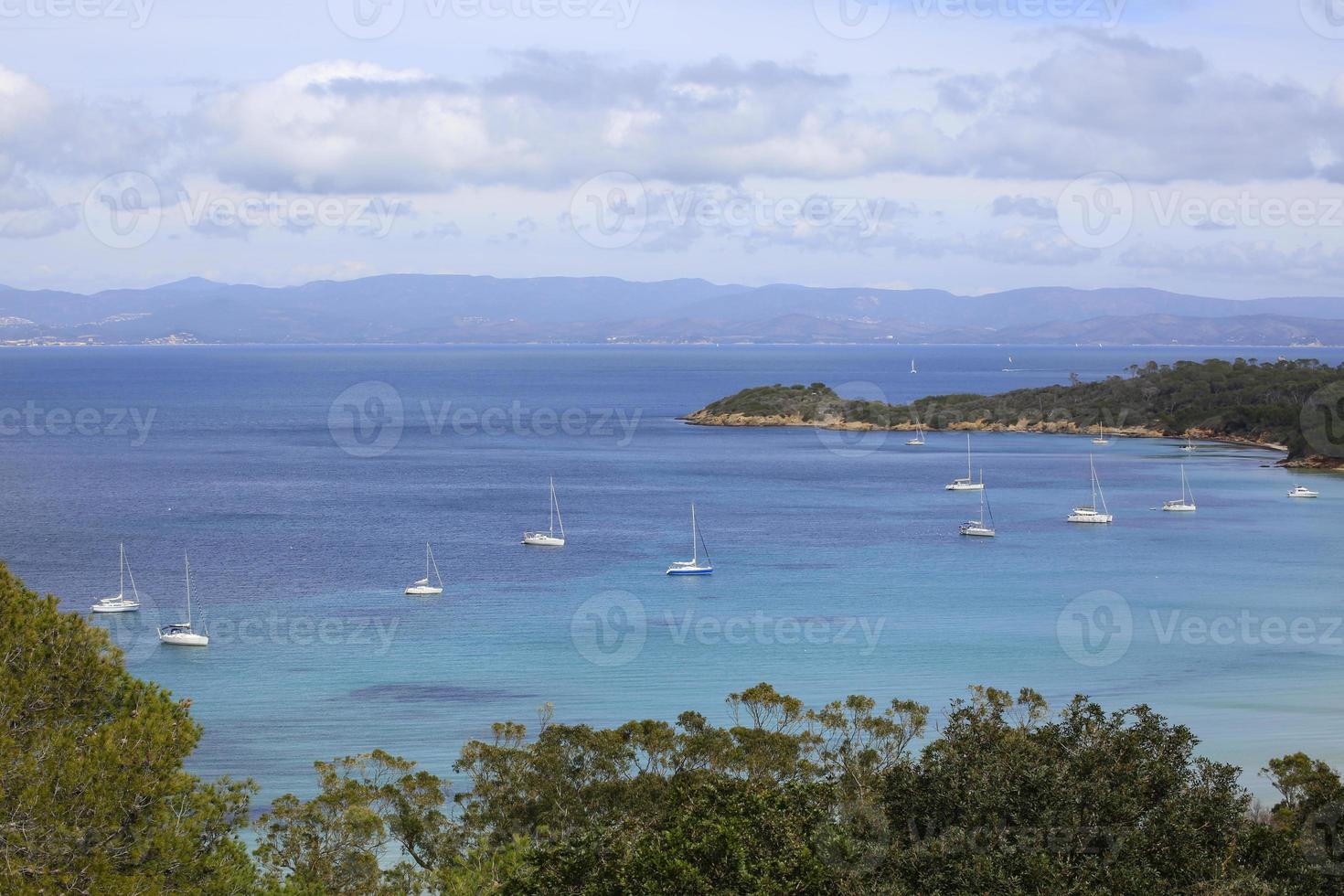 costa da ilha de Porquerolles com veleiros brancos foto