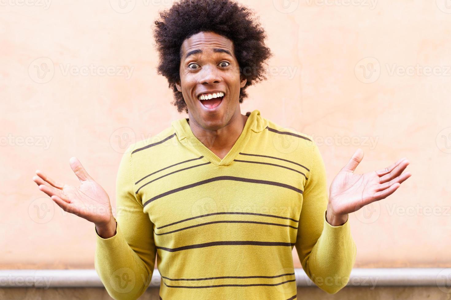 homem negro com cabelo afro com uma expressão engraçada foto