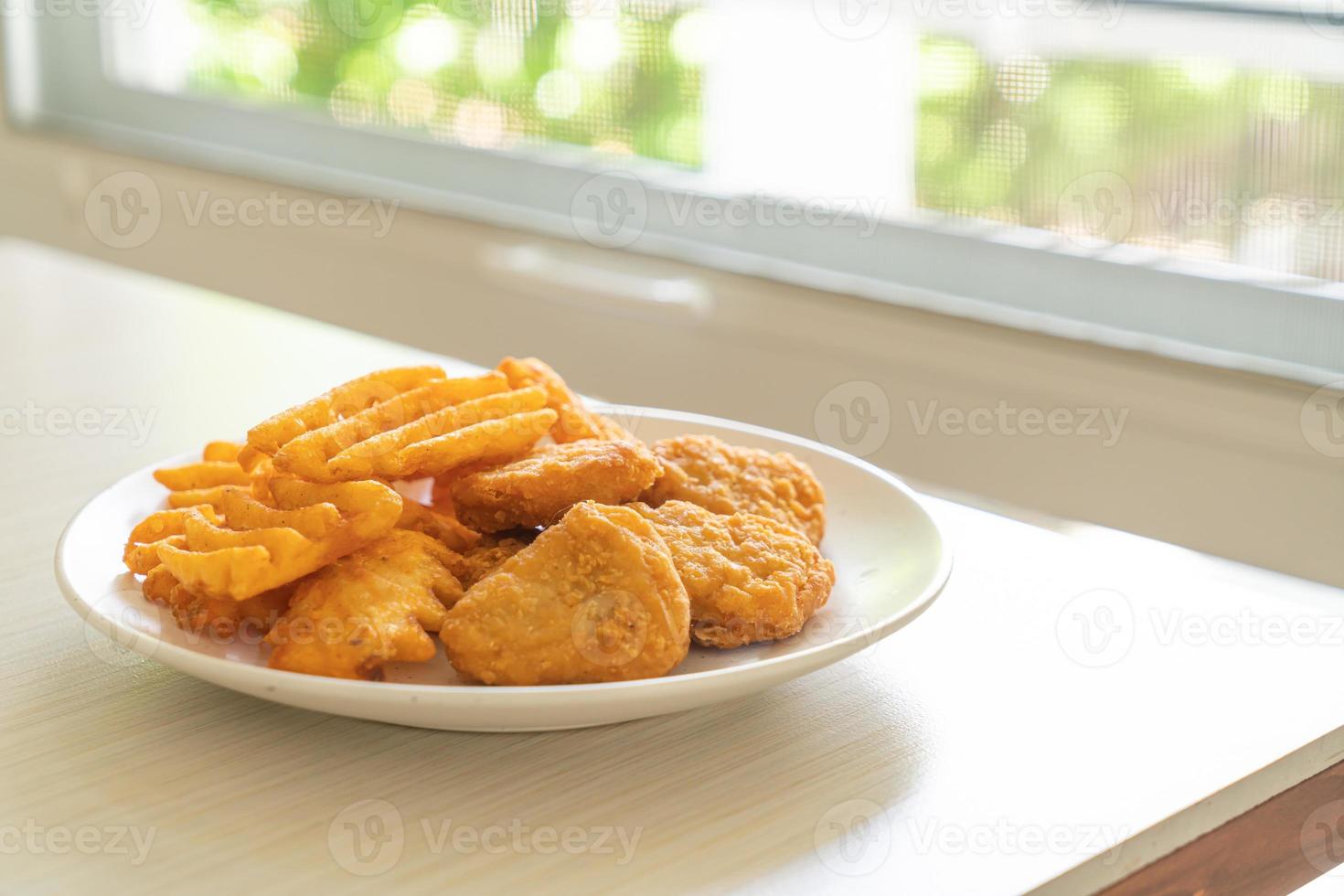 nuggets de frango frito com batatas fritas foto